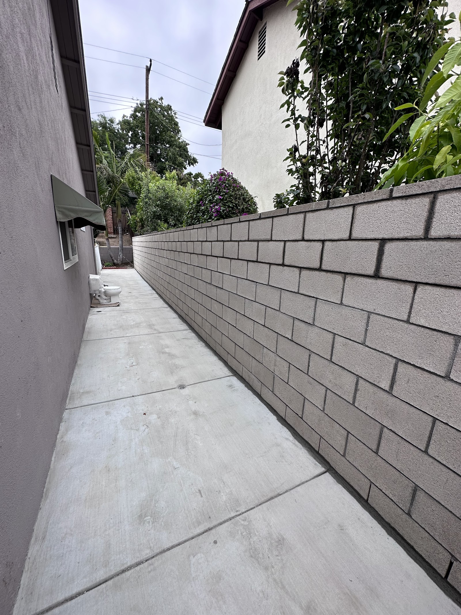 Block wall installation beside a concrete side yard path